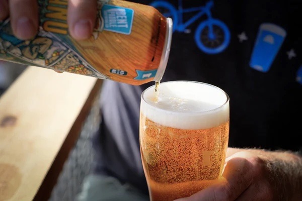 A beer is poured into a pint glass