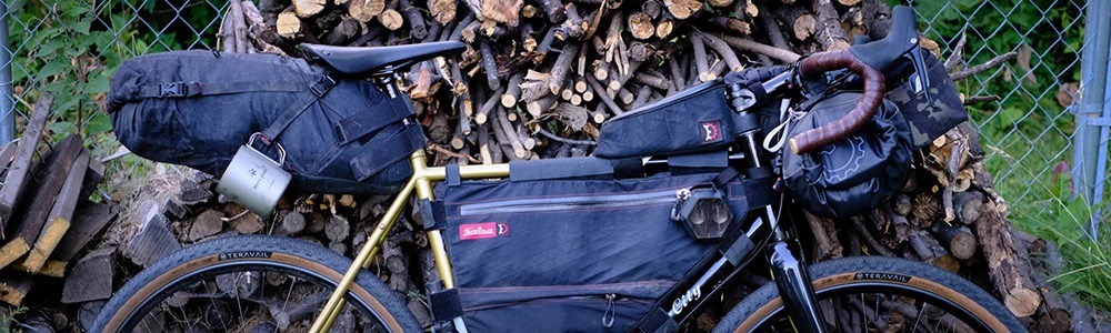 A drop bar bike shown from the side loaded with packs for a bikepacking trip