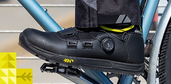 Closeup view of a rider's foot on a bike pedal while wearing black Ragnarok winter cycling boots.