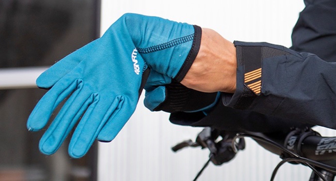 Cyclist puts on 45nrth Risor gloves with hands over the handlebars