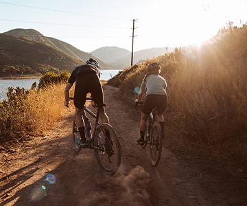 two people riding gravel bikes by river