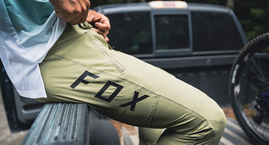 Fox downhill pants man sitting on side of truck