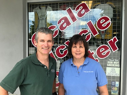 The two owners standing in front of the shop
