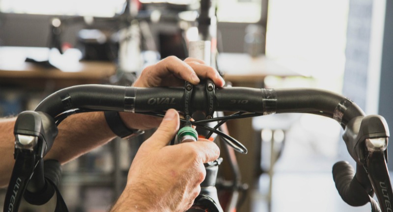 Close-up of a person attaching a handlebar to a bike frame
