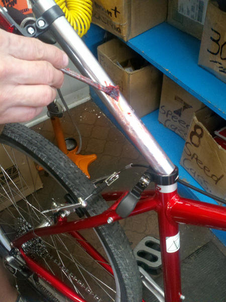Mechanic applying greast to a new seatpost